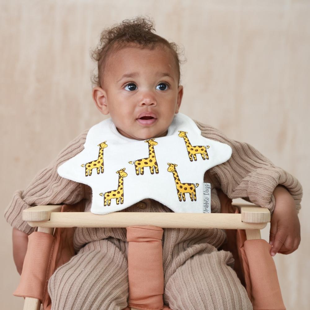 Baby wearing dribble bib with giraffes