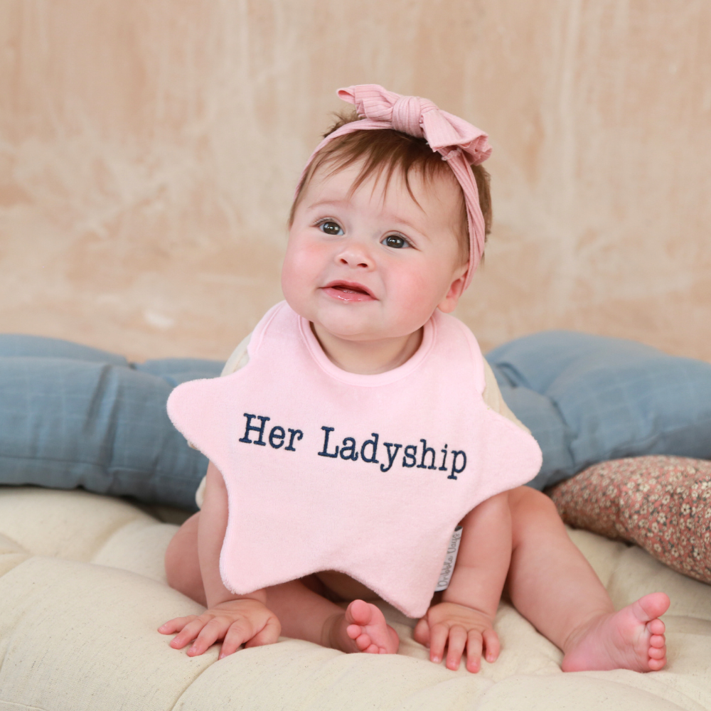 Baby wearing a star shaped bib with 'Her Ladyship' embroidered on