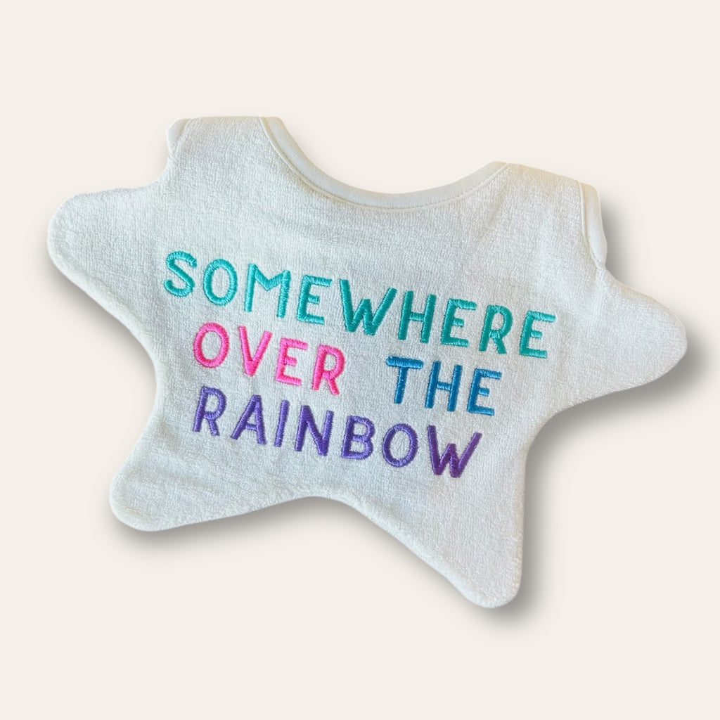 Star shaped baby bib embroidered with multicoloured text saying 'Somewhere over the rainbow'